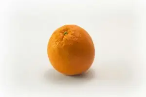 A single fresh orange isolated on a white background, symbolizing health and freshness.